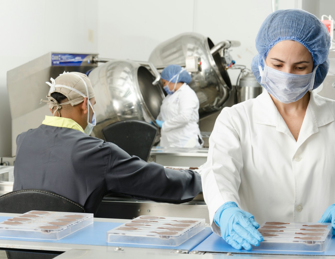 Équipe en tenue d'hygiène au travail sur une ligne de production agroalimentaire